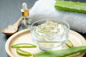 Aloe vera leaves and a moisturizing spray bottle on a bamboo tray