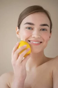 DIY lemon face mask for glowing skin – natural face whitening remedy at home with fresh lemon slices and honey.
