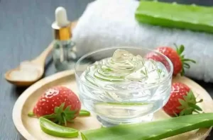 Smooth pink aloe vera and strawberry mask in a small glass container.
