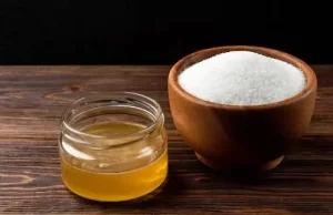 Honey and sugar being mixed in a tiny bowl.