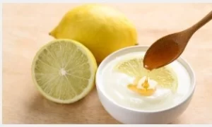 Yogurt, honey, and lemon lip mask on white plate to lighten dark lips.