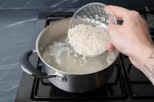 Cooked rice simmering in a pot for skincare preparation.