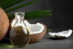 Coconut oil in a jar with fresh coconut for scalp care.