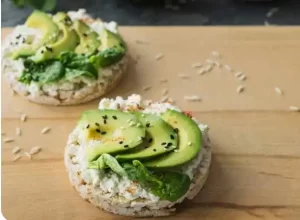 Rice cake topped with avocado as a low-calorie snack.